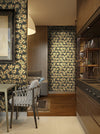 A dark, bold and moody black and gold wallpaper in a modern kitchen. Wild Lone's "Berry Galaxy" wallpaper in "Warm Black", an intricate botanical pattern, inspired by Japanese and Arts and Crafts design, with peach hypericum berries.