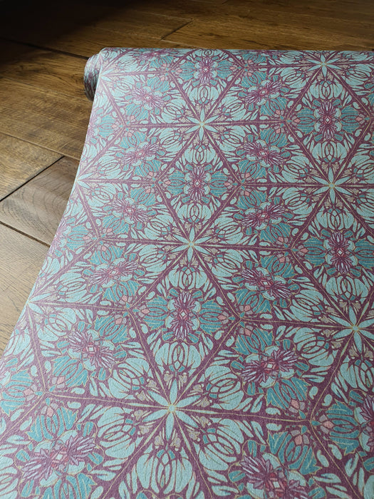 A length of Wid Lone's "Greenhouse" wallpaper in "Exotic Green", an intricate Art Nouveau and Japanese-inspired, botanic pattern, with purple, pink, greens and gold, with a gentle pearlescence and shimmer.