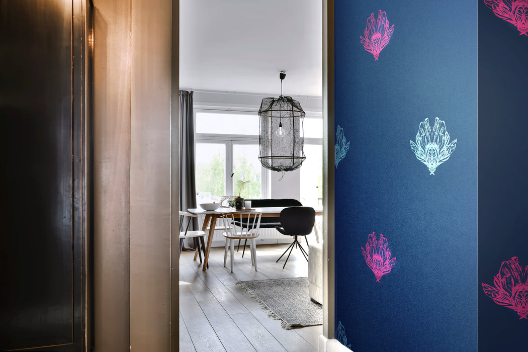 A luxurious, bold and statement wallpaper,  with a subtle pearlescence and a mood of dark romance, in a hallway in a light, eclectic apartment, featuring electric blue and magenta bee forms against a dark blue background. Wild Lone's "Night Flight" wallpaper in "Electric Blue".