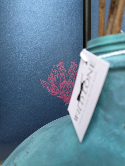 A view of a metallic magenta bee form in Wild Lone's "Night Flight" wallpaper in "Electric Blue", a subtly pearlescent, moody and bold wallpaper. 