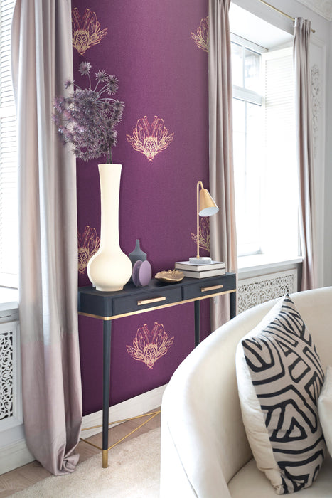 A bold, moody feature wallpaper in a luxurious living room, featuring a gold, fantastical bee design against a purple, pearlescent background. Wild Lone's "Night Flight" wallpaper in "Purple Jewel".